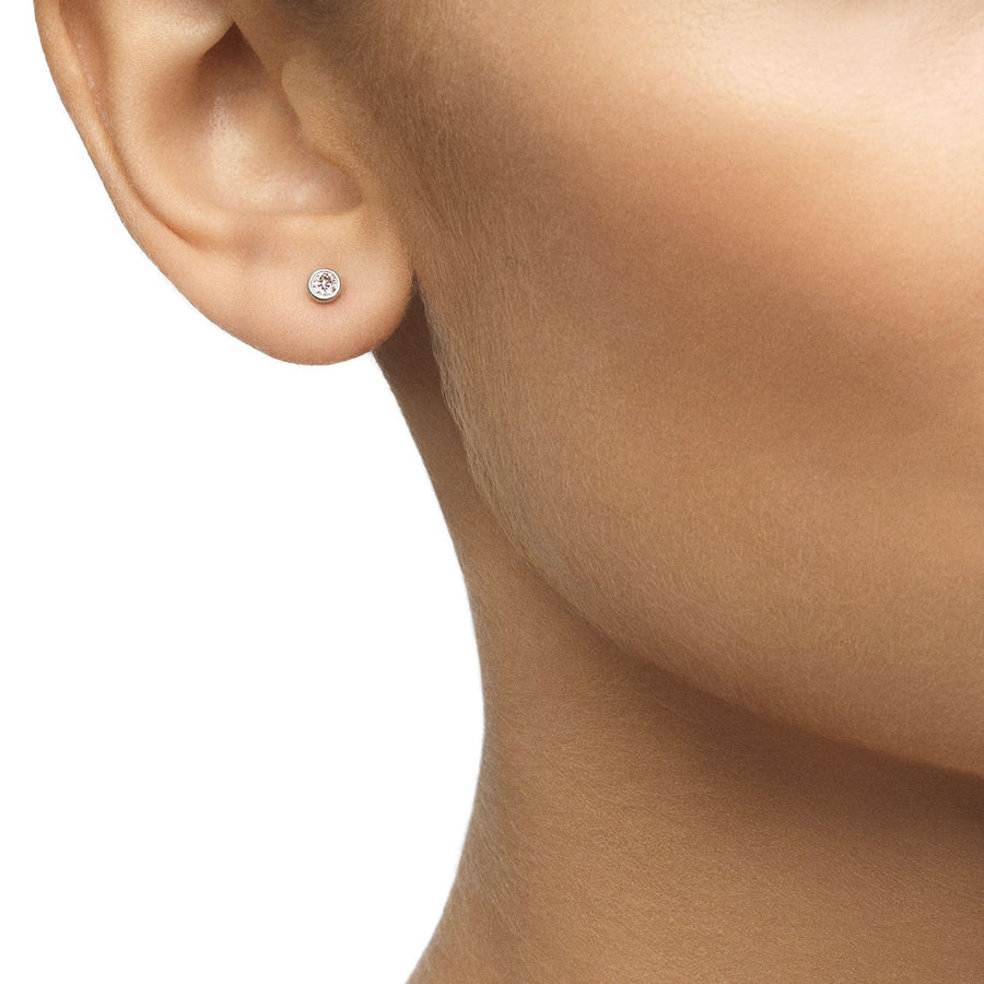 De Beers My First De Beers One Diamond Stud Earrings in 18 karat white gold with diamonds totaling 0.06 carats.