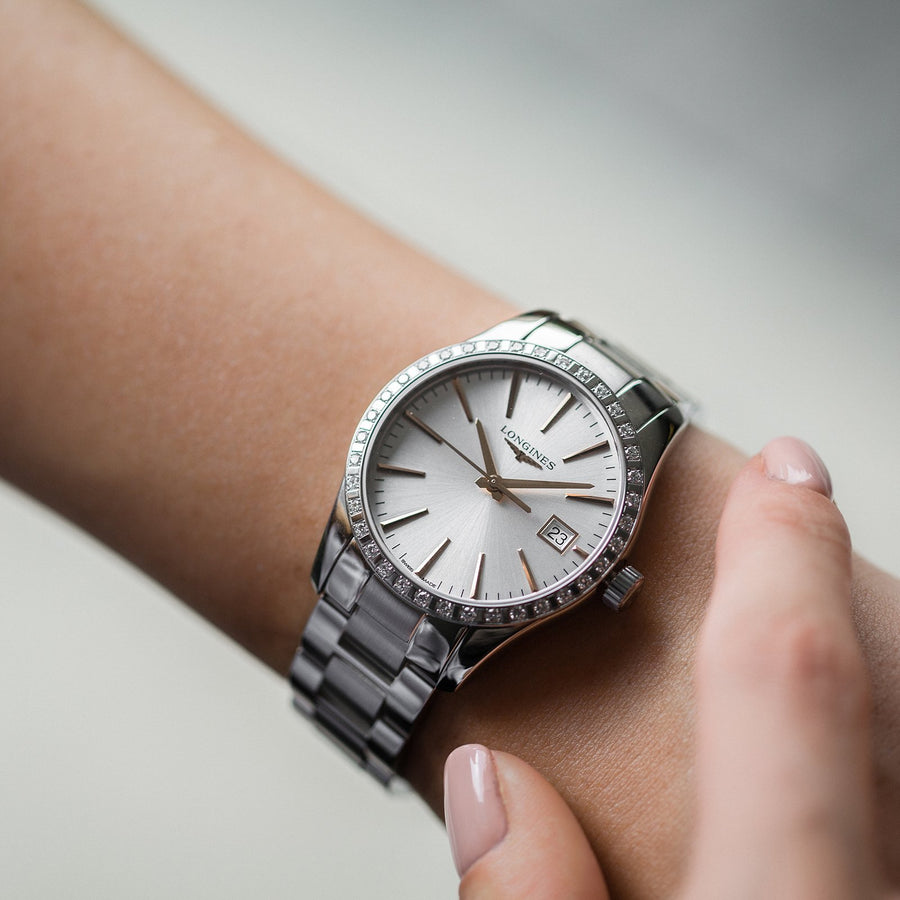 29.5mm stainless steel case with diamond bezel, silver dial. Date display. Quartz movement. Water resistance of 5 bar. Stainless steel bracelet