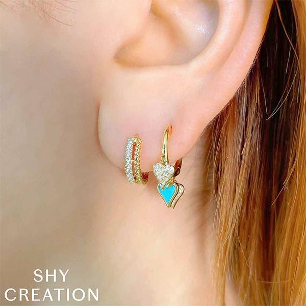 Shy Creation Mini Hoop Earrings in 14 karat yellow gold with diamonds totaling 0.19 carats.